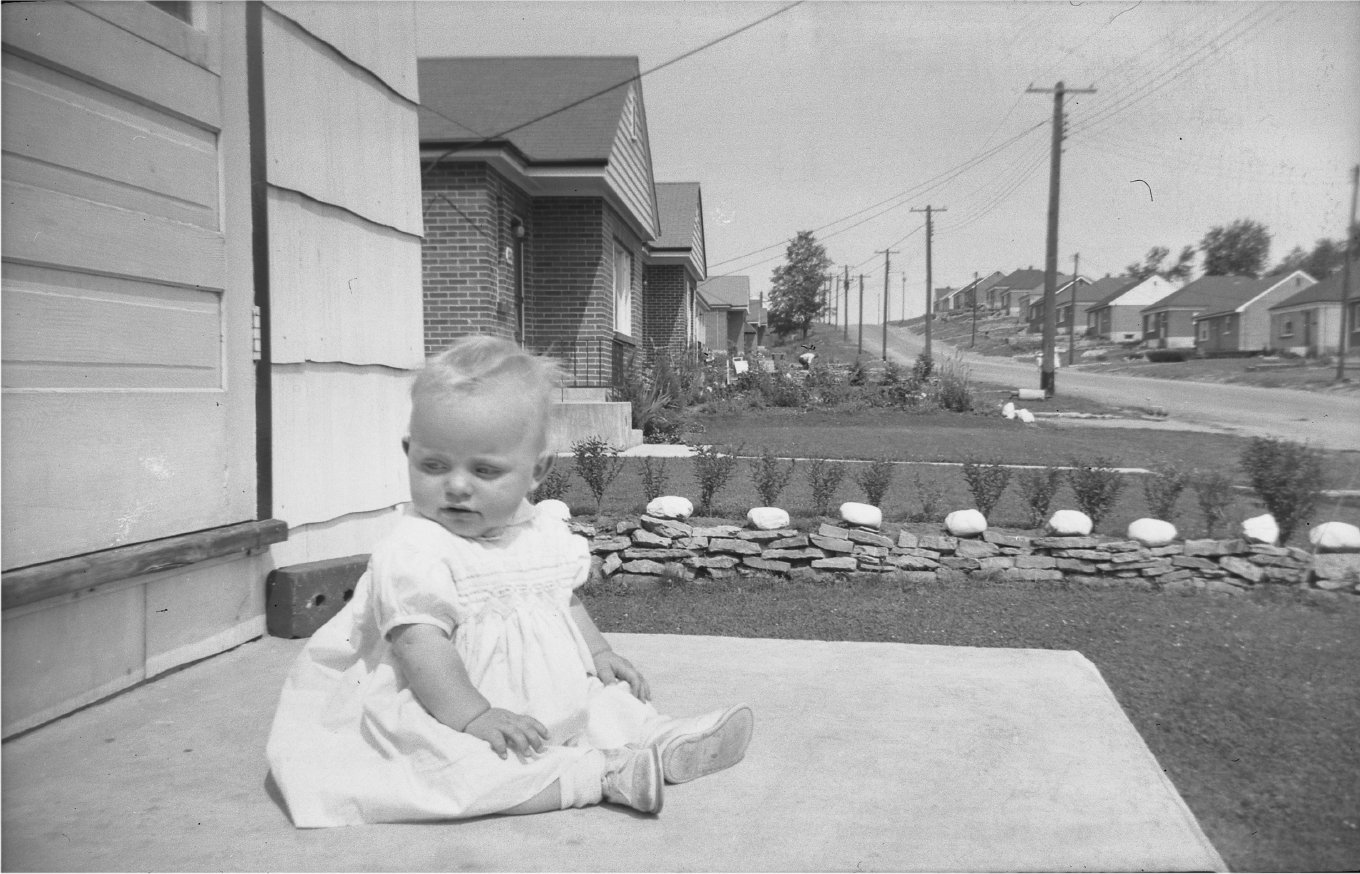 Anne Delong on front porch 254 Caddy St 1950 looking east